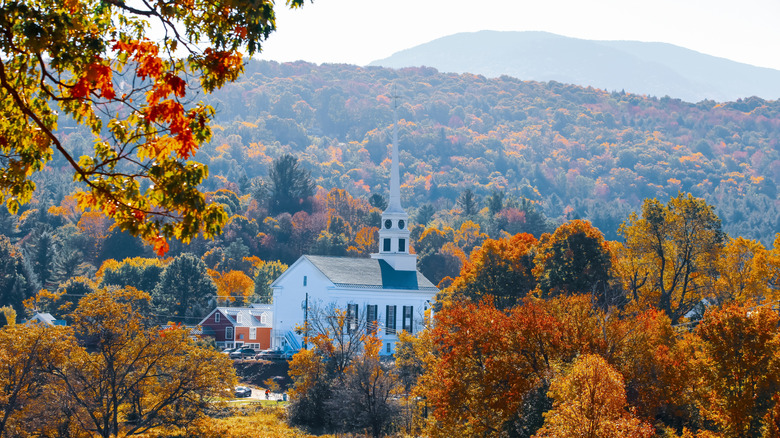 A white church in a small town in Vermont with autumn foliage.