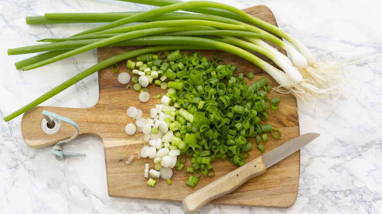 Scallions whole and chopped on a board