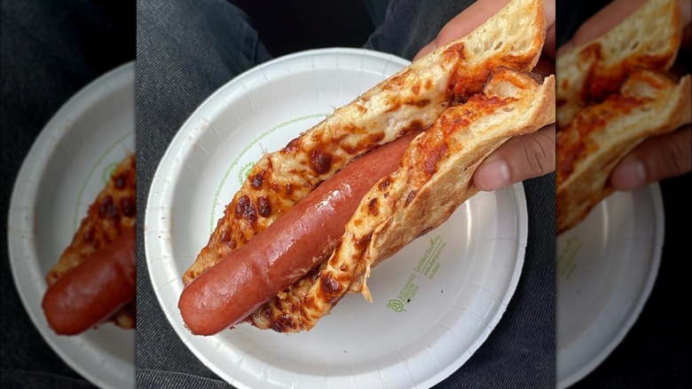 Costco hot dog folded inside cheese pizza slice