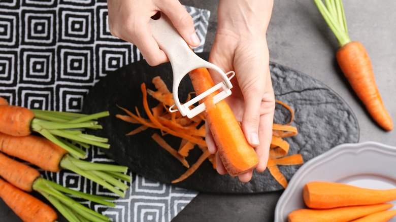 person peeling a carrot into ribbons