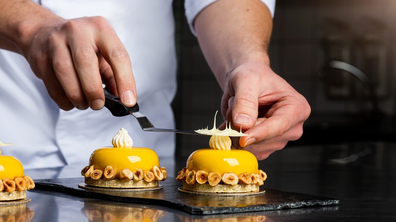 Pastry chef garnishing dessert