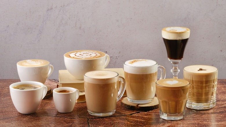 Various espresso-based beverages in different glassware on a brown countertop