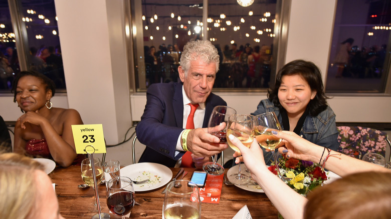 Anthony Bourdain dining and drinking wine in New York City