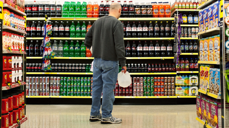 man shopping in dollar store drink aisle