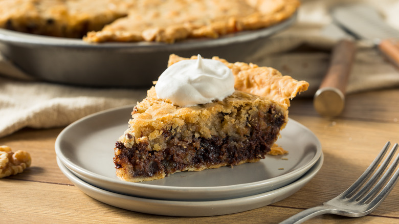 slice of Derby Pie with whipped cream on white plate