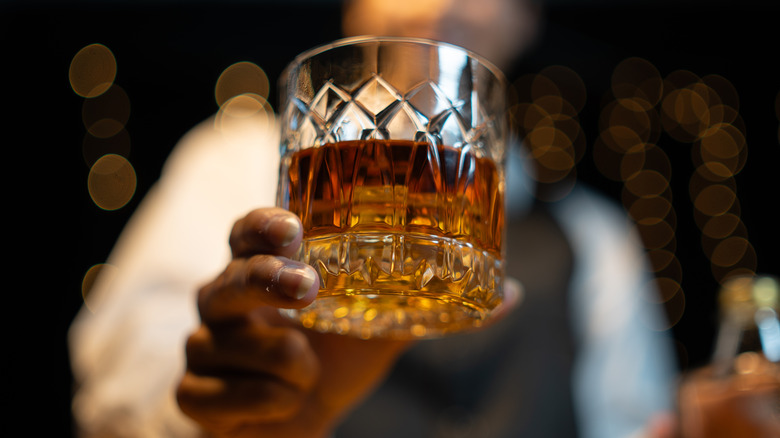 bartender handing out a glass of bourbon