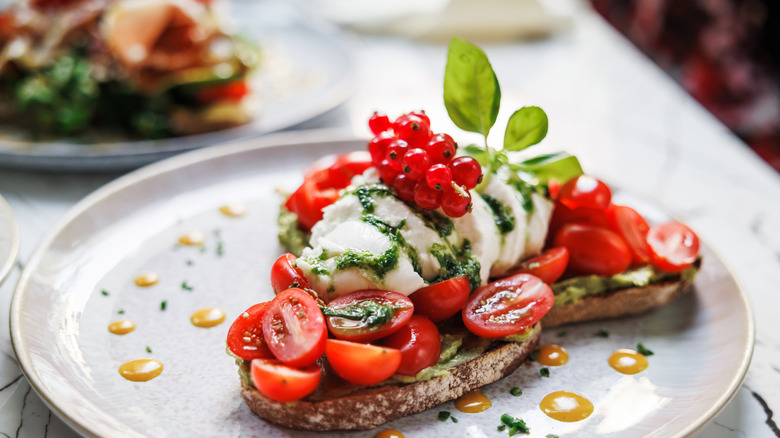 avocado toast plated with tomatoes