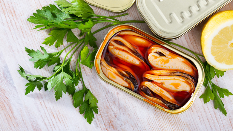 Opened mussel can with herbs