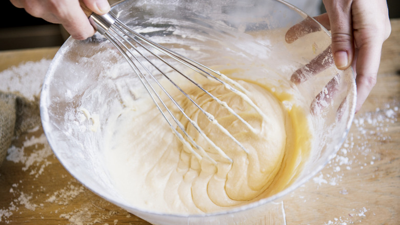 Person mixing cake batter with whisk