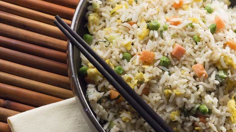 fried rice in a bowl with chopsticks.