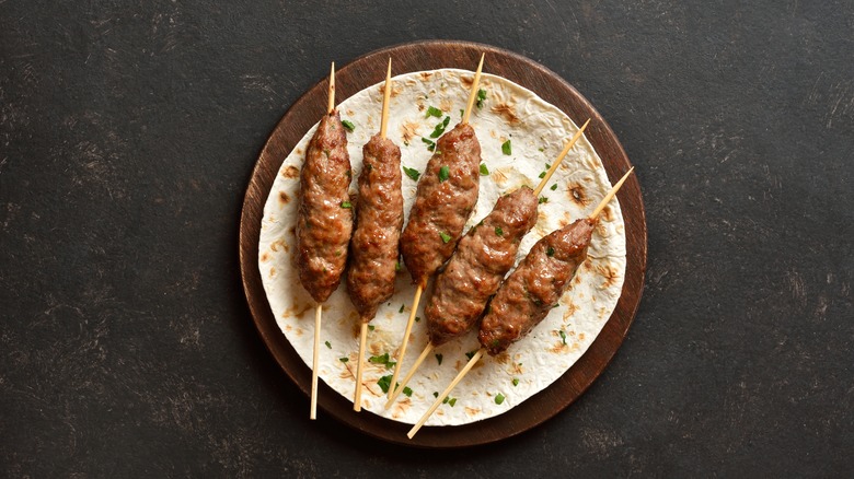 kebabs on sticks on a pita