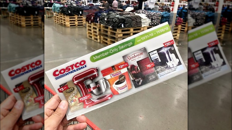 Person holding a Costco coupon book
