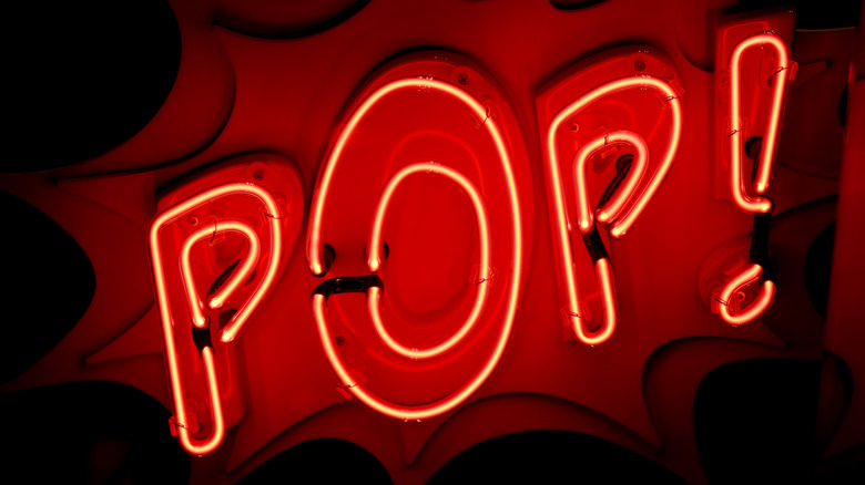 a neon sign reading "pop!"