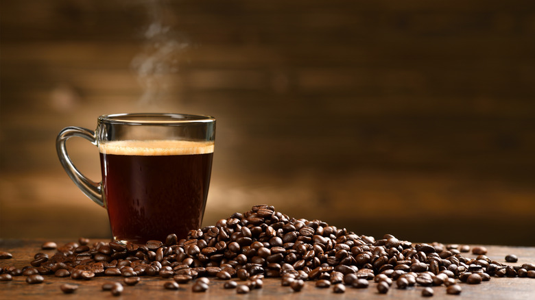 Dark coffee beans and a cup of coffee