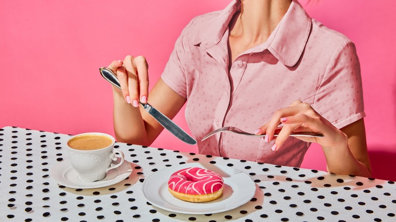 person enjoying coffee and a donut