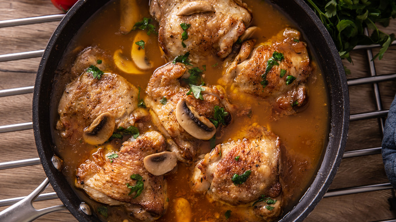 Chicken cooked with mushrooms in a pan