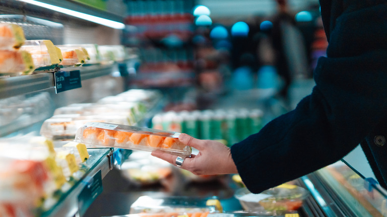 Person holding grocery store sushi