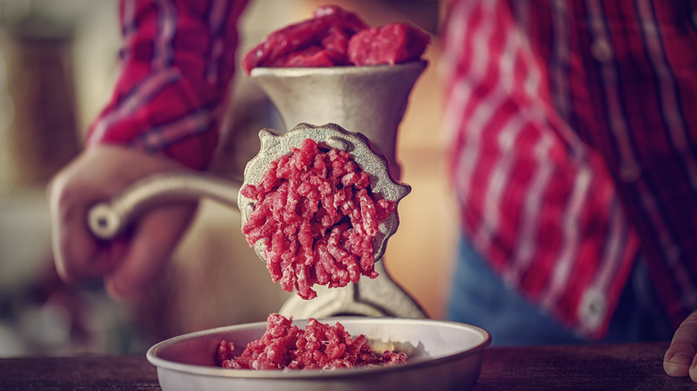 person grinding meat 