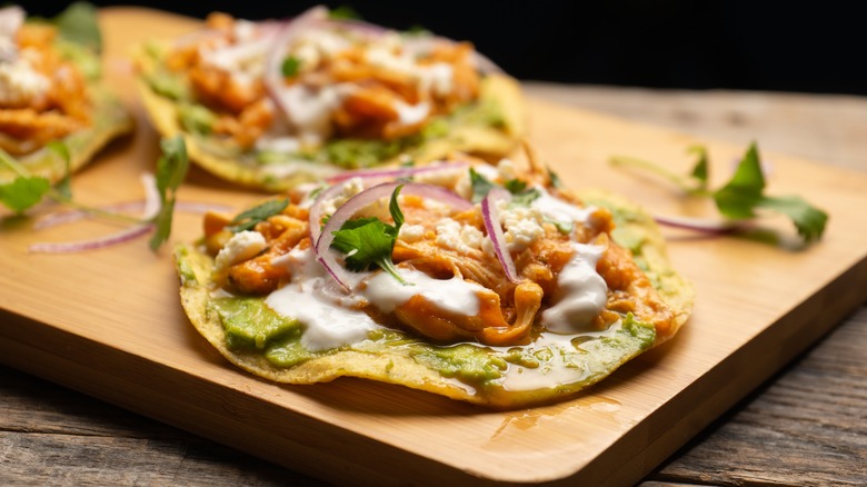 Tostadas with chicken on a wooden board