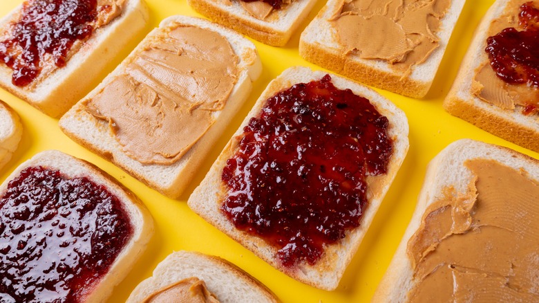 Slices of white bread with peanut butter and jelly.