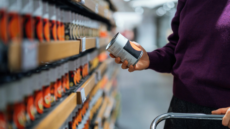 customer looking at a can of soup in the store