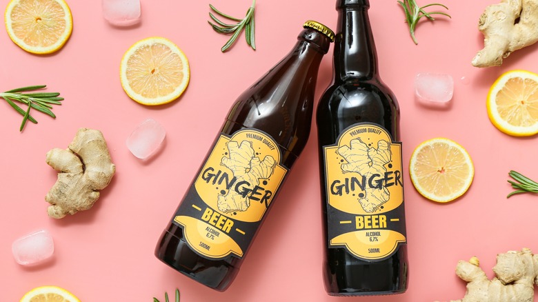 Two bottles of ginger beer on a pink background