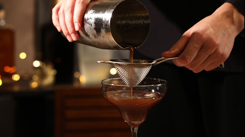 Bartender double-straining an espresso martini