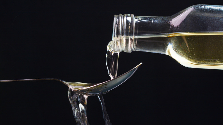 pouring apple cider vinegar on spoon