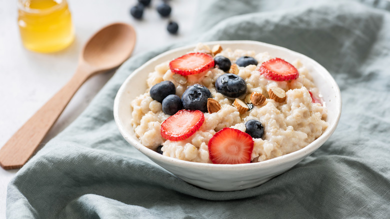 A bowl of oatmeal topped with almonds and berries