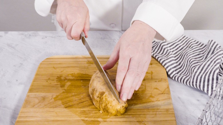 Chef slicing russet potatoes