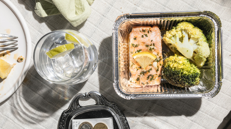 Leftover food in takeout container on restaurant table