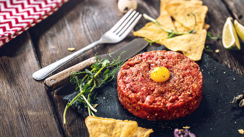 A beef tartare with an egg yolk on top.