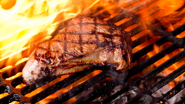 Steak on grill with flames 