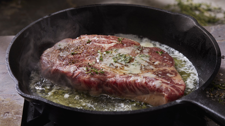 Steak, butter, herbs in pan