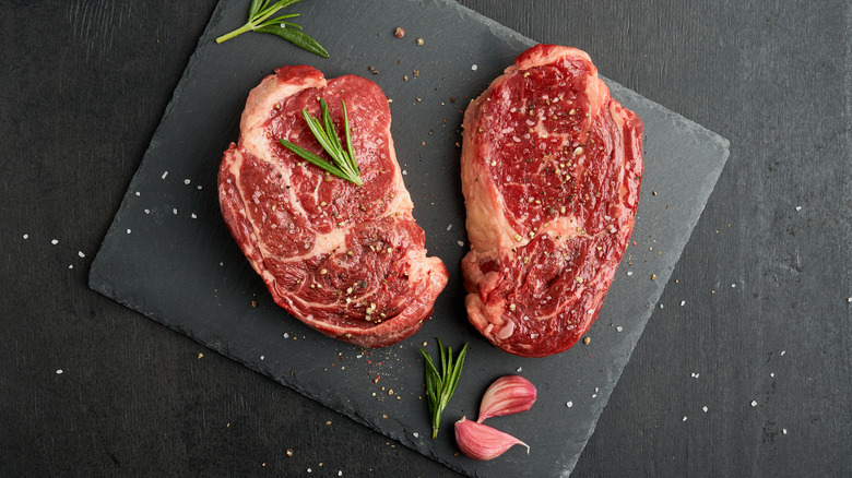 Raw ribeyes on a cutting board