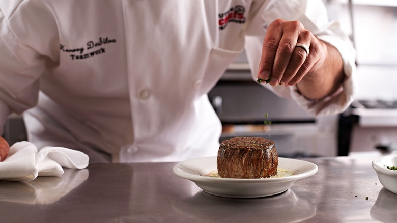 A Ruth's Chris cook finishing a steak