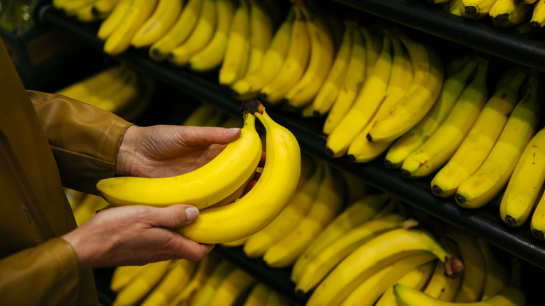 Person holding bananas at store