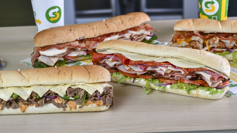 Assortment of footlong subs on a countertop.