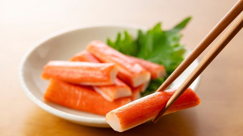 picking up imitation crab meat from bowl with chopsticks