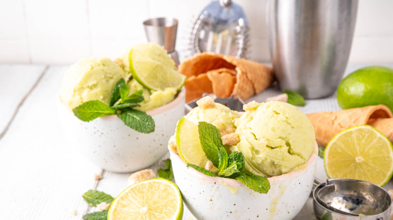 Bowls of homemade sorbet surrounded by limes and barware in a bright, tidy setting.