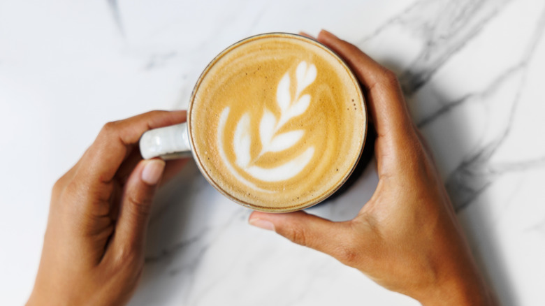 Latte in a mug with hands