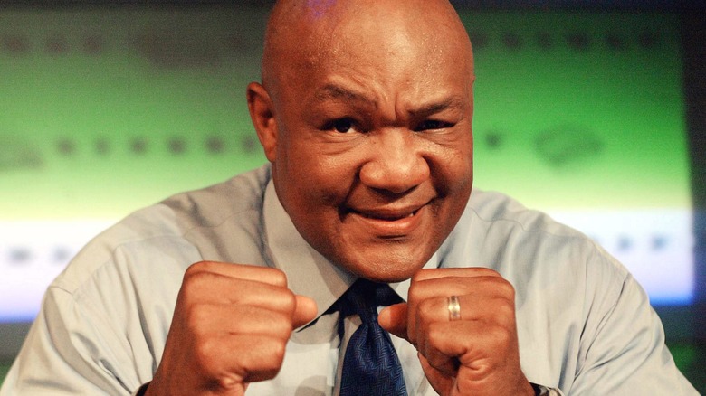 George Foreman smiling and holding up his fists.