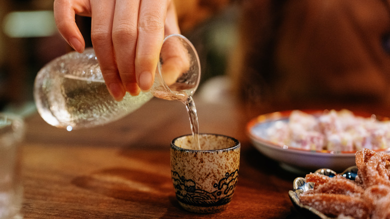 Person pouring sake into a cup