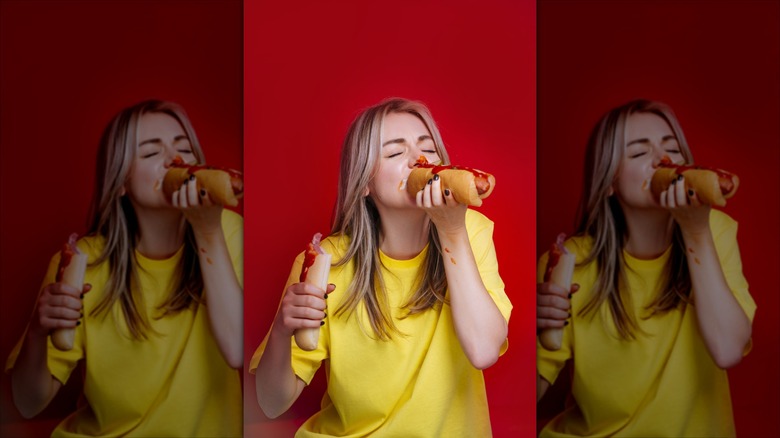 Woman stuffing a hot dog in her mouth