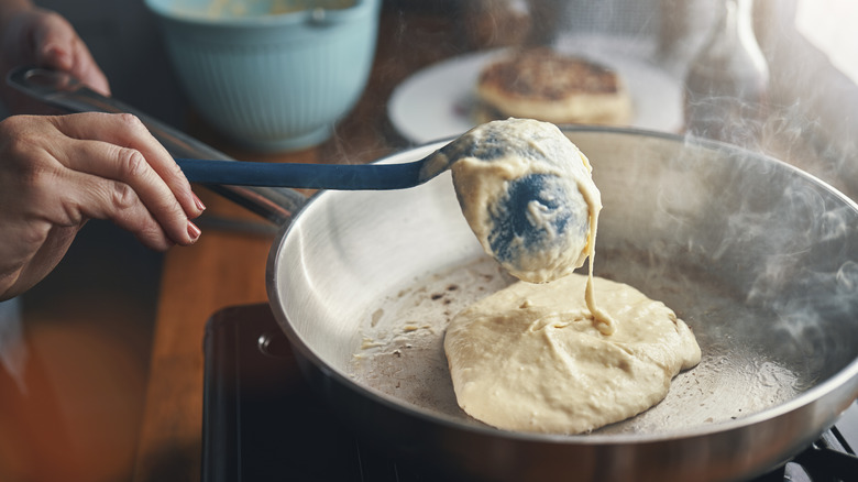 Ladling pancake batter on frying pan