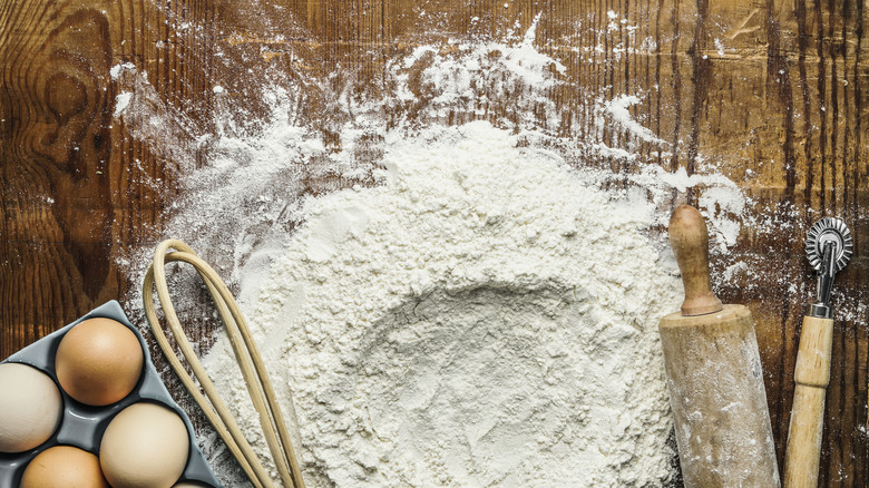 Baking ingredients including too much spilled flour on a cutting board.