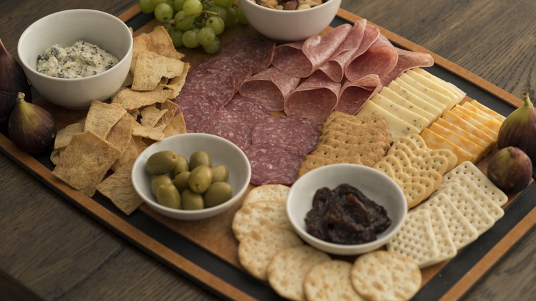 a charcuterie board with thin square cuts of cheese