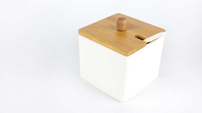 A ceramic salt container with a wooden lid