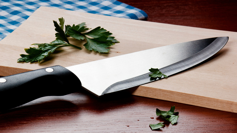 Knife and herbs on a wooden cutting board