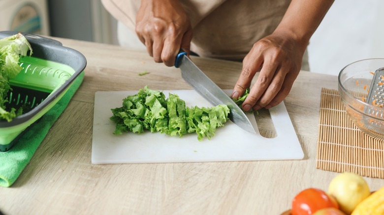 Person chopping lettuce with a chef's knife